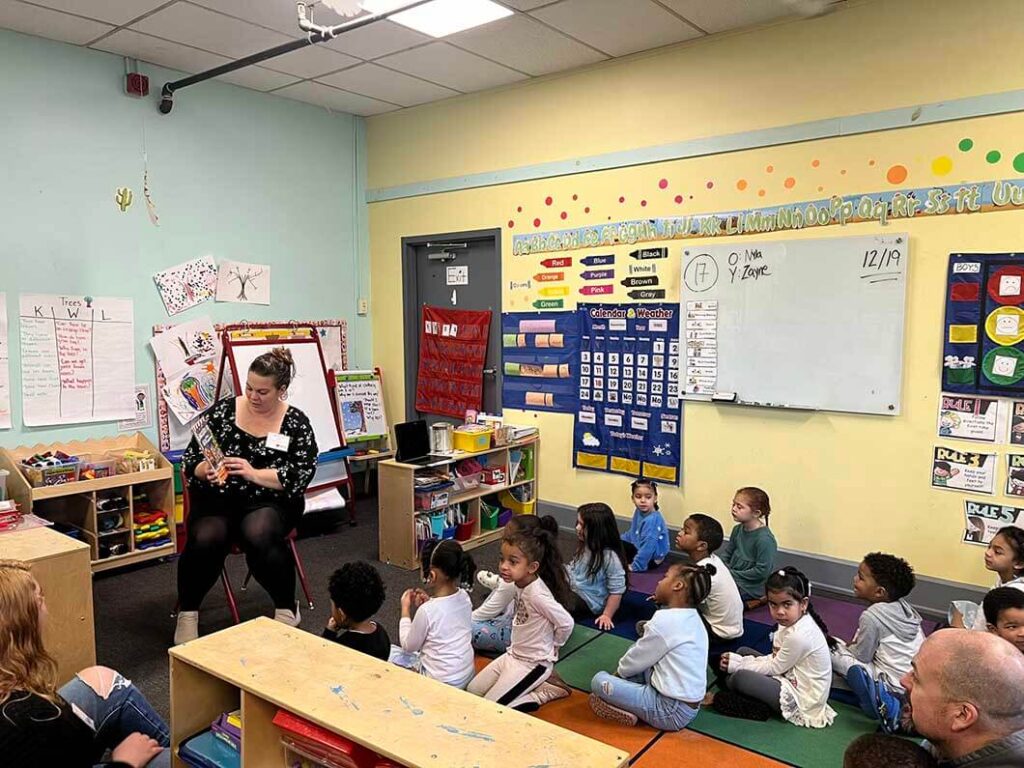 Volunteer reading book to day care class