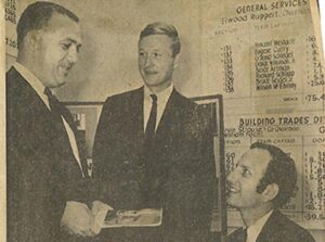 In a 1968 newspaper clipping three men discussing the Loaned Executive program